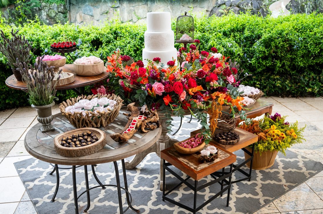 Mesa de doces rústica com flores coloridas e bolo